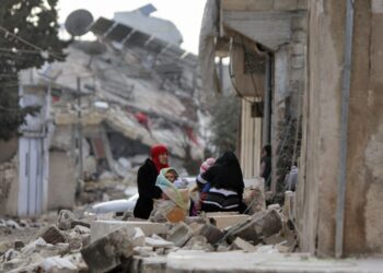 SEORANG wanita Syria memangku anaknya dalam cuaca sejuk di kawasan bencana gempa bumi di bandar Jandairis, semalam. - AFP