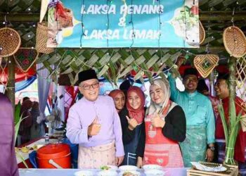 WAN Rosdy Wan Ismail (kiri) bersama penduduk ketika melawat sebuah kiosk makanan di Majlis Ramah Mesra Dan Jamuan Hari Raya Aidilfitri di Dewan Terbuka Kampung Mela, Lipis baru-baru ini. – UTUSAN/HARIS FADILAH AHMAD