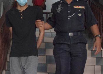 HAYAT Shamas yang dikawal anggota polis memasuki bangunan Mahkamah Sesyen Melaka, semalam bagi tuduhan merompak dan merogol seorang wanita. – UTUSAN/ RIZANIZAM ABDUL HAMID
