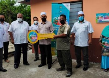 IDRIS Ahmad (empat dari kanan) menyerahkan replika kunci kepada Azidi Sudin (tiga dari kanan) penerima MyHaus Yayasan Pembangunan Ekonomi Islam Malaysia (YaPEIM) Perak di Kampung Seri Aman, Menglembu, Ipoh, Perak, hari ini. - FOTO/ASLIZA MUSA