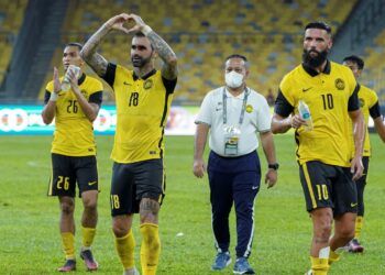 GUILHERME de Paula (kiri) memberi penghormatan kepada penyokong Harimau Malaya selepas tamat perlawanan persahabatan menentang Brunei di Stadium Nasional, Bukit Jalil kelmarin. - UTUSAN/FARIZ RUSADIO