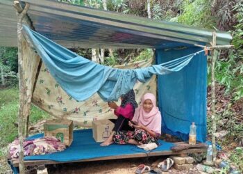 SITI Hajar Kamarudin (kanan) dan adik-beradiknya mengikuti sesi PdPR dalam pondok di Kampung Seberang, Tanjung Buloh, Lipis, Pahang, semalam. – UTUSAN/HARIS FADILAH AHMAD