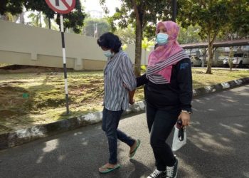 N.G. Annie Maria (kiri) dibawa ke Mahkamah Majistret Seremban atas lapan tuduhan menipu berhubung pengeluaran komisen pelaburan di Seremban. - UTUSAN/AHMAD ZULKARNAIN SYED ALI