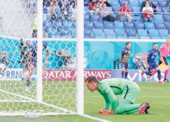 PENJAGA gol Poland, Wojciech Szczesny terduduk dan hanya mampu memerhati sahaja bola masuk ke gawang buat kali kedua ketika menentang Slovakia. – AFP