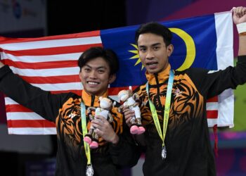 MUHAMMAD Syafiq Puteh (kanan) dan Gabriel Gilbert Daim meraikan kejayaan meraih pingat perak dalam acara 3m papan anjal seirama Sukan Komanwel 2022 di Birmingham, hari ini. - AFP