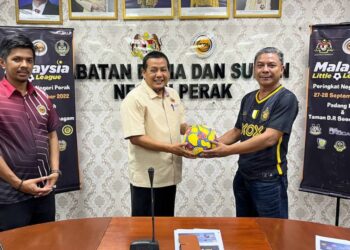 MEOR Azli Meor Mahmud (kanan) menyerahkan sumbangan bola kepada Mohd. Soufi Ibrahim sempena Pertandingan  Pertandingan Liga Bola Sepak Tunas Malaysia Little League di Ipoh hari ini. - UTUSAN/IHSAN PERAK FC