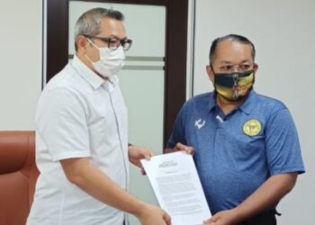 HAKIMI Halim (kanan) menyerahkan memorandum penyelesaian isu gaji pemain kepada Khairul Affendee Salim di Ipoh hari ini.  - UTUSAN/AZIZAN HASHIM