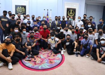 SAARANI Mohamad (tengah) bersama pemain dan pegawai Perak FC yang menerima sumbangan duit raya di Ipoh hari ini. - UTUSAN/IHSAN PERAK FC