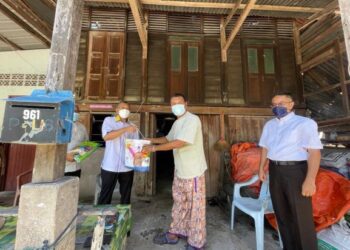 AZLAN MAN (kiri) menyampaikan sumbangan bungkusan makanan dan wang tunai kepada Bahar Che Mat, 49, semasa melawat rumahnya di Kampung Padang Besar Selatan, Kuala Perlis hari ini.- UTUSAN/NAZLINA NADZARI