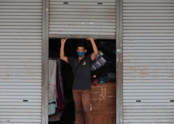 SEORANG pemilik premis pakaian membuat persediaan kembali beroperasi di Kompleks Tok Arau, Perlis hari ini.- UTUSAN/SHAHIR NOORDIN