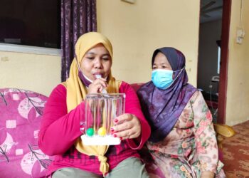 NORAZLINA Alias melakukan senaman penafasan di rumahnya di Kampung Teriang, Jelebu, semalam. Di sebelahnya Kamariah Kamarudin. – UTUSAN/NOR AINNA HAMZAH