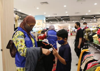 SUKARELAWAN Zurich Malaysia membantu anak yatim mencuba pakaian baharu bagi menyambut Hari Raya Aidilfitri.