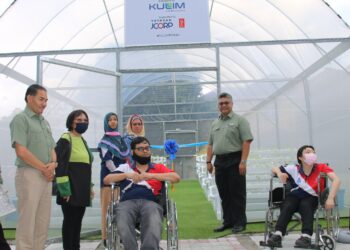 Pengarah Urusan Kulim, Mohd. Faris Adli Shukery (berdiri, kanan) ketika melawat rumah hijau khas yang dibina untuk membantu pesakit OKU cerebral palsy di Johor.