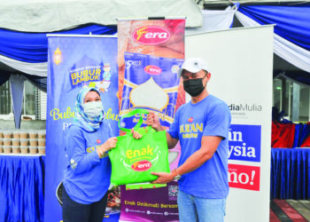 NURAZUMY Najid menyerahkan cenderamata kepada Ketua Pegawai Kewangan Media Mulia Sdn. Bhd., Abd. Wahid Idris dalam Program Kongsi Berkat Bubur Lambuk anjuran Era Foods MY dan Media Mulia di Tebing Bandar Dato Onn, Johor Bahru kelmarin. – UTUSAN/RAJA JAAFAR ALI