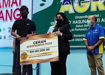 HASLINA Abdul Hamid (tengah) menyampaikan replika cek kepada salah seorang wakil penerima geran program Agropreneur Muda peringkat negeri Perlis di dewan serbaguna kampus Unimap Kubang Gajah, Arau, Perlis, hari ini. - FOTO/SYED AZLAN SAYID HIZAR