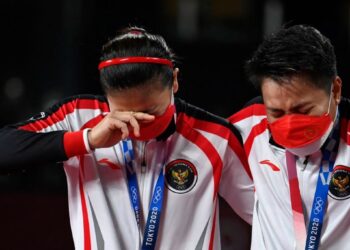 GREYSA Polii (kiri) dan Apriyani Rahayu tidak mampu menahan sebak sepanjang lagu kebangsaan Indonesia dimainkan selepas memenangi pingat emas beregu wanita Sukan Olimpik 2020 di Tokyo semalam. - AFP