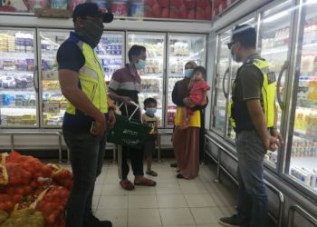 ANGGOTA polis Hulu Terengganu melakukan pemantauan di sebuah pasar raya bagi memastikan masyarakat di daerah itu mematuhi prosedur operasi standard (SOP) ditetapkan. - FOTO/NOOR HAYATI MAMAT