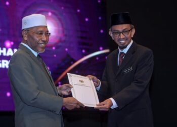 IDRIS Ahmad menyampaikan Anugerah Perkhidmatan Cemerlang kepada pegawai Hal Ehwal Islam, Mohd. Radhi Abdul Ghani di Kompleks Islam Putrajaya, Putrajaya. - FOTO/FAISOL MUSTAFA
