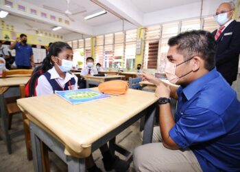 TAMPIN 18 Okt.- RADZI Jidin, beramah mesra dengan murid sekolah ketika mengadakan lawatan ke SK Tengku Zainun, Tampin hari ini.-UTUSAN/MOHD SHAHJEHAN MAAMIN