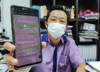  CHA Kee Chin menunjukkan pesanan WhatsApp yang diterima beliau daripada seorang individu tidak dikenali ketika ditemui pemberita di pejabatnya di Seremban, hari ini. - UTUSAN/BADRUL HAFIZAN MAT ISA