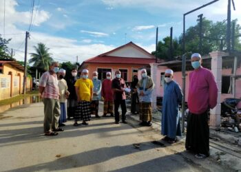 MOHD. Fairuz Hamzah (tengah) menerima sumbangan dikumpul daripada warga Kampung Rawai, Marang, Terengganu bagi membantu meringankan beban keluarganya yang kehilangan rumah akibat kebakaran. 
