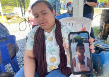 ATIKAH ABDUL RAHMAN menunjukkan gambar Mohd. Faizal Hisyam Mat Taib yang mayatnya ditemukan berhampiran pokok paya bakau, dekat Jeti Tok Kuning, Perlis.
