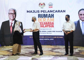 ISMAIL Sabri Yaakob menyerahkan kunci kepada penerima Rumah Ikram Keluarga Malaysia di KPKT, Putrajaya. 