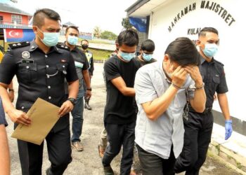 PEMILIK kilang (depan) bersama pekerja warga Indonesia berjalan memasuk bangunan Mahkamah Majistret Kulai kerana memasang Bendera Jalur Gemilang secara terbalik di Kulai semalam. - FOTO/BAAZLAN IBRAHIM