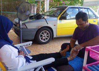 MUHAMMAD  Zulfadli Rosmadi mengurut kaki pelanggan di rumahnya di Kampung Bakau Tinggi di Kemaman, hari ini. - NIK NUR IZZATUL HAZWANI NIK ADNAN