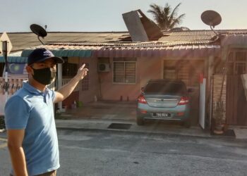 NAH Iqbal Ahmad Nah Rodzi menunjukkan bumbung rumah jirannya yang rosak akibat angin lintang di Fasa 3A Seri Manjung, Perak,  hari ini. - UTUSAN/SHAMSUL KAMAL AMARUDIN