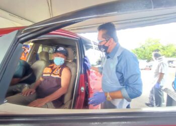 MOHD. Salim Mohd. Sharif (kanan) bertanya khabar dengan salah seorang penerima vaksin menerusi Program Pemberian Vaksin Bergerak Parlimen Jempol di Pusat Komuniti Desa (PKD) Serting Ilir, Jempol, hari ini.-UTUSAN/NURULAZMA SHAFIQAH KHAIRUL AZHAR