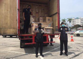 RAMLI Mohamed Yusoof (tengah) menunjukkan rokok putih tidak bercukai yang dirampas di Hentian Rehat dan Rawat Gambang dan dibawa ke pekarangan IPK Pahang di Kuantan, Pahang. - UTUSAN/DIANA SURYA ABD WAHAB