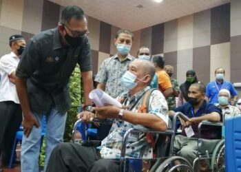 ROSOL Wahid beramah mesra dengan seorang penerima vaksin dalam Program Outreach Vaksinasi di Politeknik Hulu Terengganu di Hulu Terengganu, hari ini. - FOTO/NOOR HAYATI MAMAT