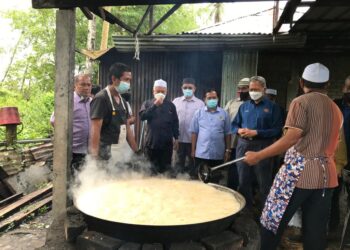 MUSTAPA Mohamed meluangkan masa melihat penduduk menghasilkan gula melaka di Kampung Kelong, Tumpat, Kelantan, hari ini. - UTUSAN/ROSLIZA MOHAMED