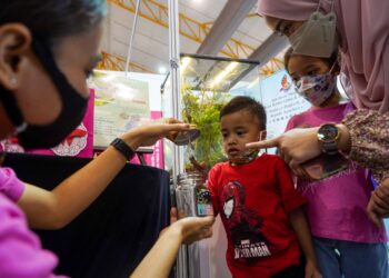 SEORANG petugas menunjukkan kepompong rama-rama kepada pengunjung MAHA 2022 di Serdang, semalam. – UTUSAN/MUHAMAD IQBAL ROSLI