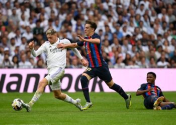 Federico Valverde (kiri) berjaya mengatasi pemain tengah Barca Gavi dalam aksi El Clasico di Santiago Bernabeu, sebentar tadi.-AFP