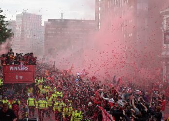 Liverpool's players wave to supporters from an open-top bus during a parade through the streets of Liverpool in north-west England on May 29, 2022, to celebrate winning the 2021-22 League Cup and FA Cup. - Despite the disappointment of losing to real Madrid in the final of the UEAF Champions League, Klopp has called on Liverpool fans to take to the streets of the city on Sunday when they parade the League Cup and FA Cup. (Photo by Oli SCARFF / AFP)