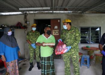 Mohamad Aimran Hakim Abdul Alim menyampaikan sumbangan kepada penduduk kampung yang terjejas semasa PKP 3.0. – UTUSAN/SHAHIR NOORDIN