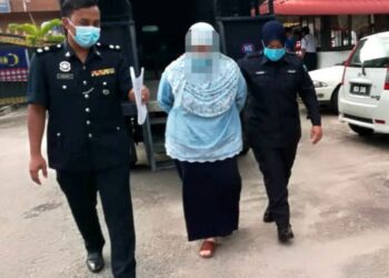 SUSPEK (tengah) dibawa ke Mahkamah Majistret Tampin oleh polis bagi mendapatkan perintah reman ke atasnya untuk membantu siasatan kes pecah amanah melibatkan nilai lebih RM1.5 juta. - UTUSAN/NOR AINNA HAMZAH