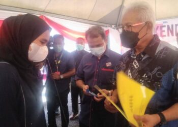 HAMZAH Zainudin menyampaikan dokumen pengenalan diri kepada penduduk di Kampung Tapah, Sungai Bayor Selama di Larut hari ini. - UTUSAN/WAT KAMAL ABAS