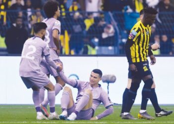 PERTAHANAN Al Nassr, Nawaf Boushal (kiri) membantu  Cristiano Ronaldo bangkit ketika menentang Al-Ittihad pada separuh akhir Piala Super Saudi di Stadium Antarabangsa King Fahd, Riyadh semalam. – AFP