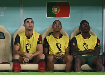 CRISTIANO Ronaldo (kiri) duduk di bangku simpanan pemain selepas tidak diturunkan dalam kesebelasan utama Portugal menentang Switzerland dalam saingan 16 terakhir Piala Duna, baru-baru ini. – AFP