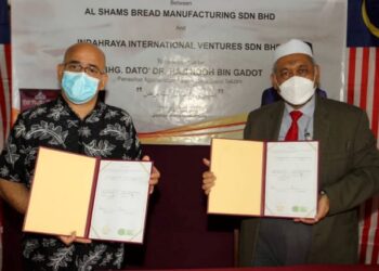 RAHIM Zalizadeh (kiri) dan Roslin Abd. Rahman selepas menandatangani perjanjian pembelian ekuiti di Kilang Al Shams Bread di Tampoi, Johor Bahru, Johor.