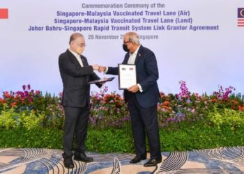 WEE KA SIONG (kiri) dan S Iswaran bertukar dokumen sempena pelancaran VTL Udara dan darat di Singapura. - IHSAN Kementerian Pengangkutan