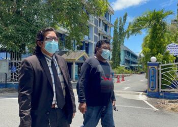 WAN AZHAR HARUN (kanan) bersama Zuhair Ahmad Zakuan keluar dari IPD Kangar selepas tampil menafikan penglibatannya dalam kes  penyeludupan keluar Muhammad Sajjad Kamaruz Zaman dari Padang Besar, Perlis hingga ke Bangkok, Thailand hari ini.- UTUSAN/NAZLINA NADZARI