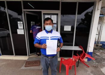 ABDUL AZIZ Jaafar menunjukkan laporan yang dibuat di Balai Polis Tanjung Kling, Melaka. - UTUSAN/AMRAN MULUP
