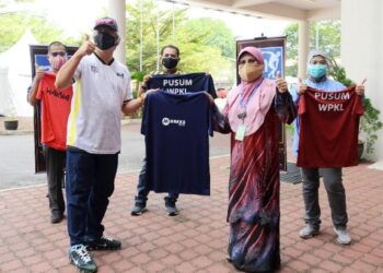 NORISMADI Abd. Manap (dua dari kiri) menyerahkan sumbangan pakaian kepada wakil Pusat Sehenti Urus Mayat di Kuala Lumpur. 