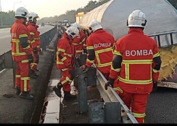 ANGGOTA bomba menjalankan kerja-kerja penyekatan dan pembersihan tumpahan minyak sawit dari sebuah lori tangki yang terlibat dalam kemalangan dengan dua buah kereta di Kilometer 276.1 Arah Utara, Lebuh Raya Utara Selatan, dekat Seremban, pagi ini.- IHSAN BOMBA