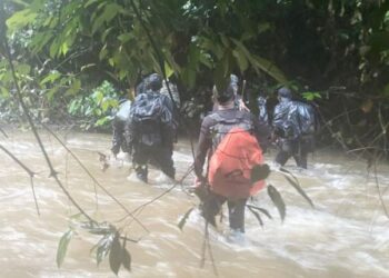PASUKAN keselamatan terpaksa meredah sungai untuk sampai ke lokasi perlombongan emas haram di Hutan Simpan Ulu Segama Malua, Lahad Datu, Sabah, Ogos lalu. – IHSAN PGA