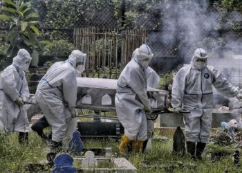 Kakitangan Pejabat Kesihatan Kota Kinabalu mengusung jenazah yang dipercayai meninggal dunia akibat Covid-19 di Tanah Perkuburan Orang Islam Taman Sempelang, Kota Kinabalu, Sabah, baru-baru ini. 
– UTUSAN/FAUZAN AZIMA